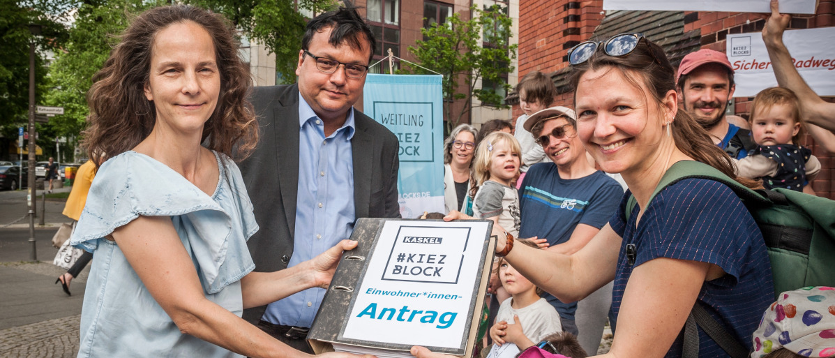 Members of a Kiezblock initiative in Berlin-Lichtenberg present a collection of signatures to the district council. 